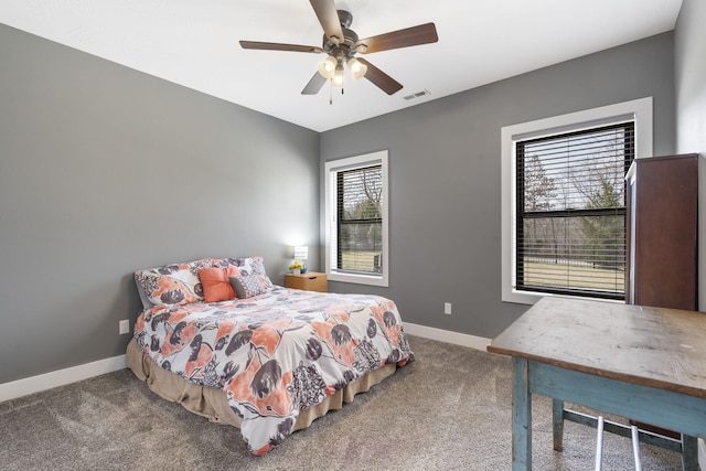 carpeted bedroom featuring baseboards, visible vents, and a ceiling fan