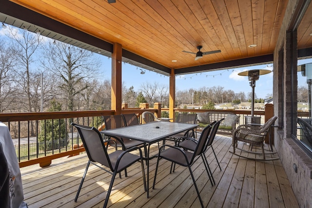 wooden deck with outdoor dining space and ceiling fan