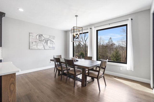 dining space with dark wood-style floors, recessed lighting, a chandelier, and baseboards