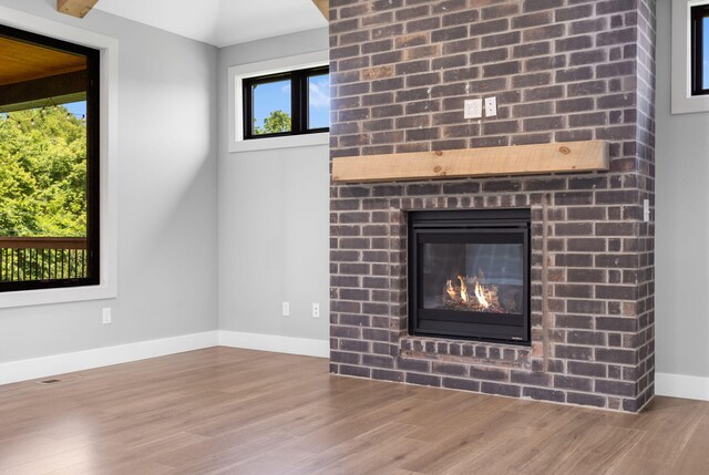 767 Thornridge Dr, Springfield, MO 65809 - detailed view of wood finished floors, baseboards, and a brick fireplace