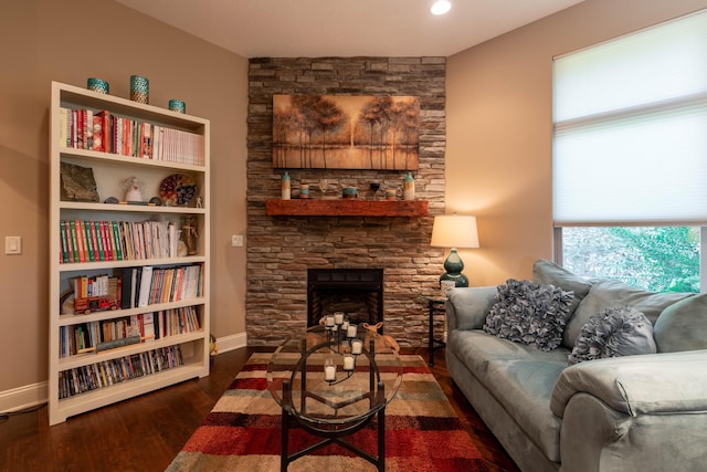 living room featuring a fireplace, wood finished floors, and baseboards