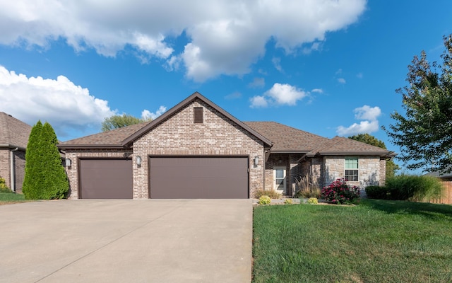 view of front of home with a garage, a shingled roof, brick siding, driveway, and a front lawn