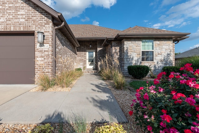 exterior space with stone siding, roof with shingles, brick siding, and an attached garage