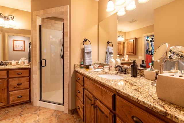 bathroom featuring a stall shower, vanity, visible vents, and tile patterned floors