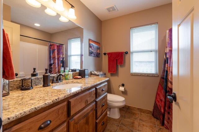 full bathroom with a shower with curtain, visible vents, toilet, vanity, and tile patterned flooring