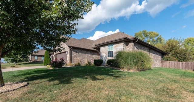 view of property exterior with an attached garage, brick siding, fence, a yard, and stone siding