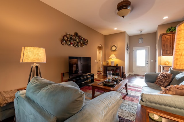 living room with baseboards, arched walkways, wood finished floors, and recessed lighting