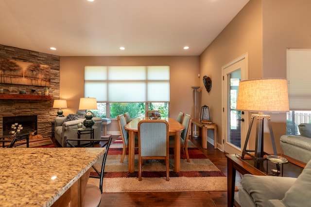 dining space featuring a healthy amount of sunlight, a fireplace, dark wood-type flooring, and recessed lighting