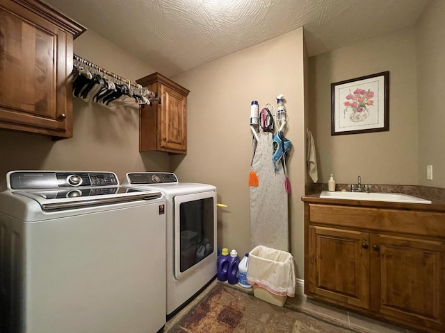 laundry room with cabinet space, washer and clothes dryer, and a sink