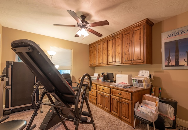 office space featuring a ceiling fan and built in study area