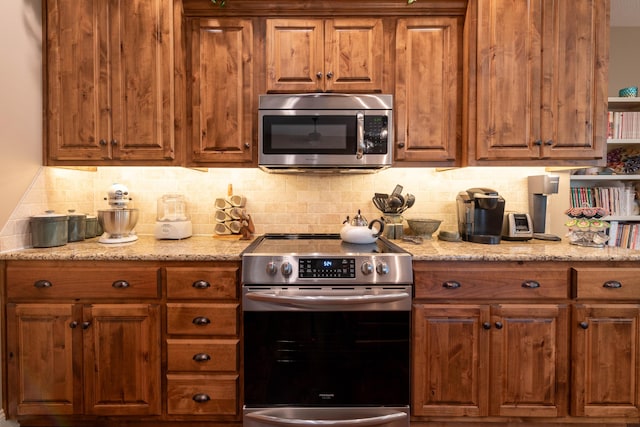 kitchen featuring appliances with stainless steel finishes and brown cabinetry