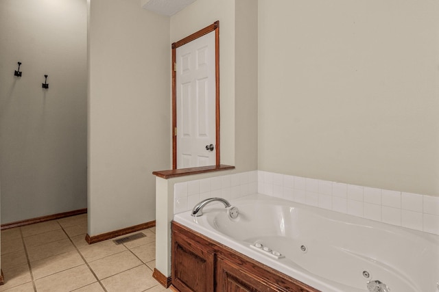 bathroom featuring visible vents, a jetted tub, baseboards, and tile patterned floors