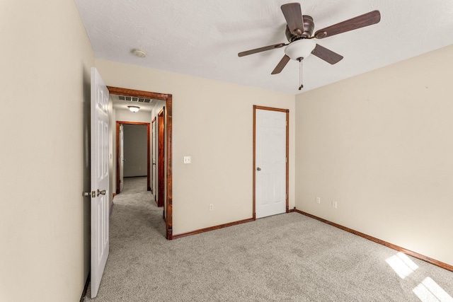 unfurnished bedroom with visible vents, baseboards, a ceiling fan, light colored carpet, and a textured ceiling