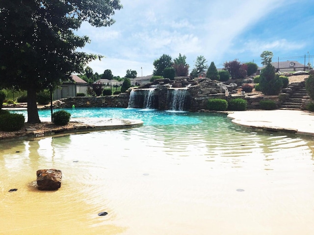 view of pool featuring fence