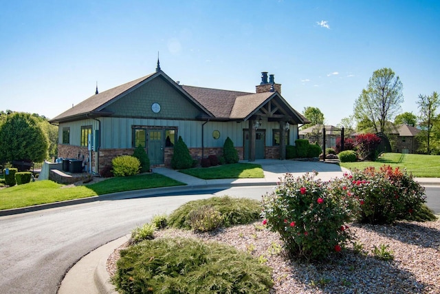 craftsman-style home with a front lawn, a chimney, and board and batten siding