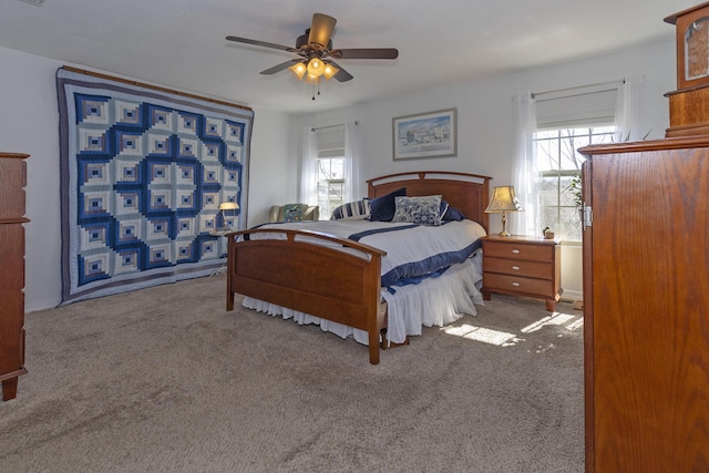 carpeted bedroom featuring a ceiling fan and multiple windows