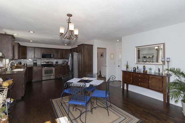 dining room featuring dark wood-style floors, recessed lighting, and a notable chandelier