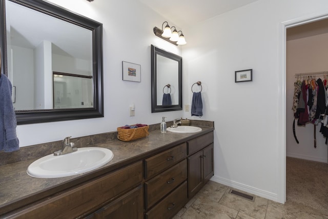 full bathroom with visible vents, a sink, baseboards, and double vanity