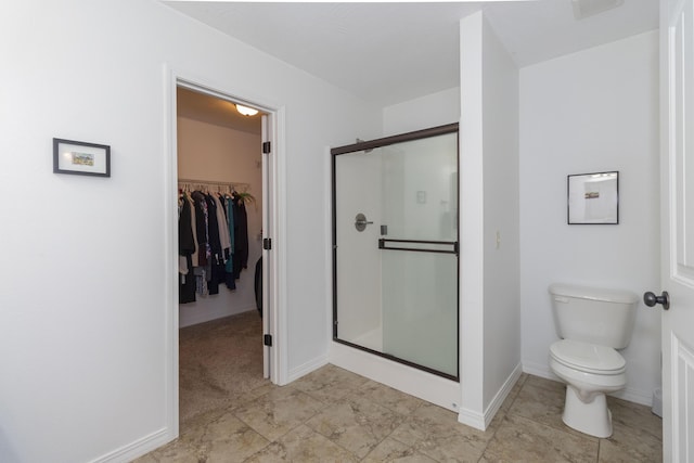 bathroom with toilet, visible vents, baseboards, a shower stall, and a walk in closet