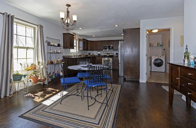 dining space featuring dark wood finished floors, recessed lighting, an inviting chandelier, washer / dryer, and baseboards