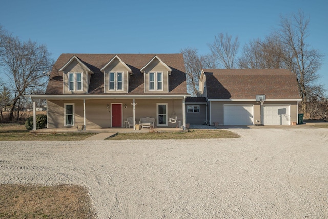 view of front of house with a garage, a porch, and gravel driveway