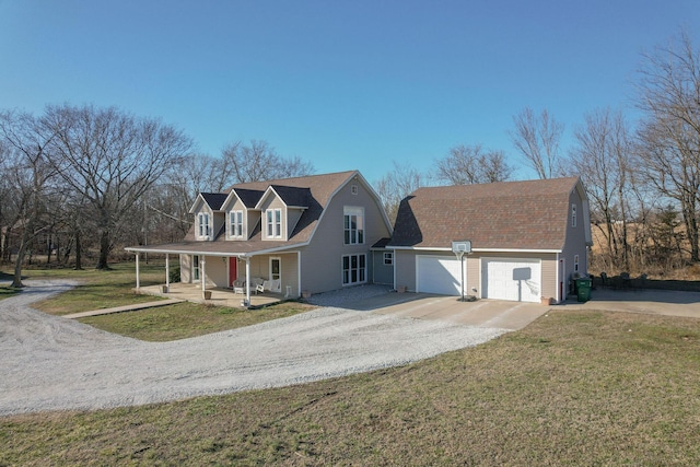 view of front of home with a front lawn, covered porch, driveway, and a gambrel roof