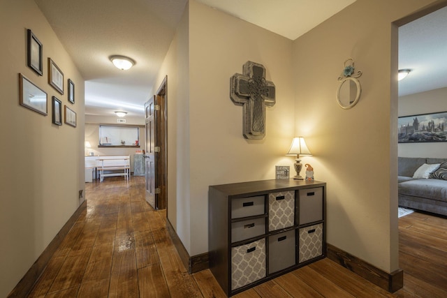 hallway with dark wood-style floors and baseboards