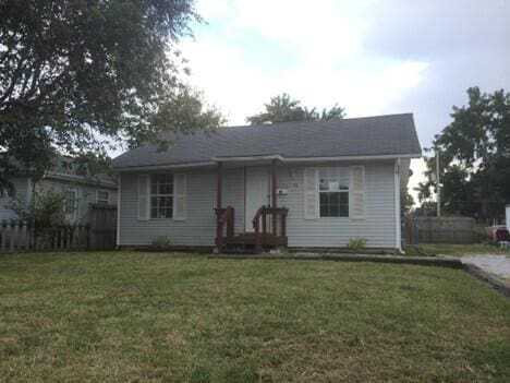 view of front of home with a front lawn and fence