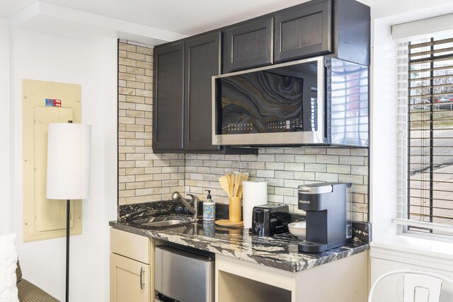 212 W Main St, Branson, MO 65616 - kitchen with a sink, stainless steel microwave, dark stone counters, and backsplash
