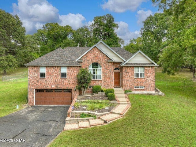 ranch-style house with driveway, roof with shingles, an attached garage, a front lawn, and brick siding