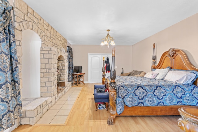 bedroom featuring wood finished floors and a notable chandelier