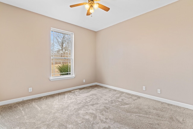 spare room featuring a ceiling fan, carpet flooring, visible vents, and baseboards