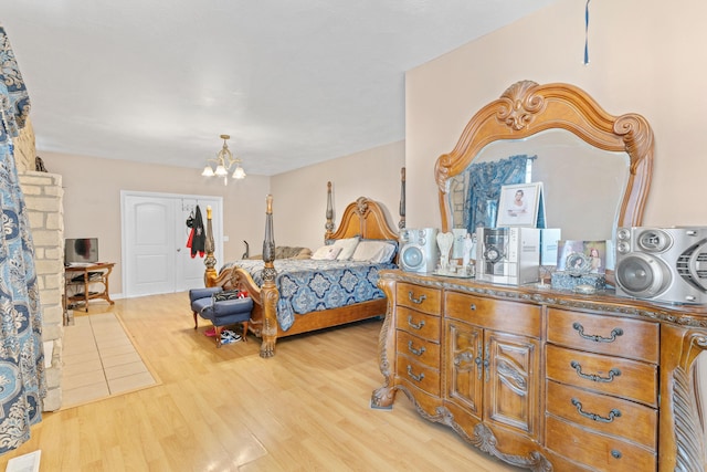 bedroom featuring light wood-type flooring and a notable chandelier