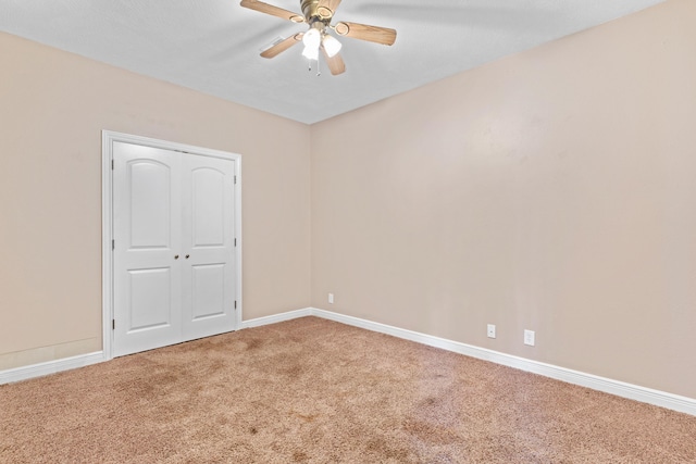 unfurnished bedroom featuring ceiling fan, carpet floors, a closet, and baseboards