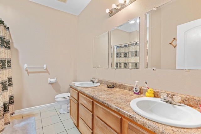 bathroom featuring double vanity, a sink, toilet, and tile patterned floors