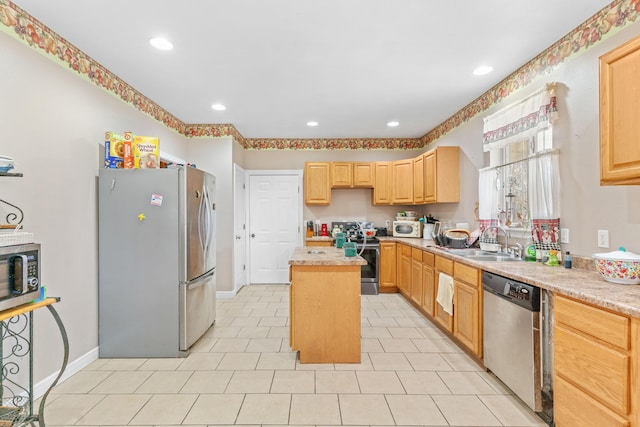 kitchen featuring a sink, light countertops, appliances with stainless steel finishes, a center island, and light brown cabinetry