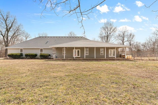 view of front of home featuring french doors, fence, and a front lawn