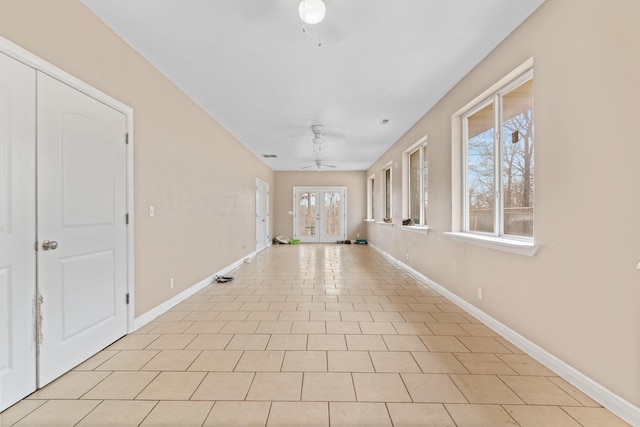 hallway with french doors, baseboards, and light tile patterned floors