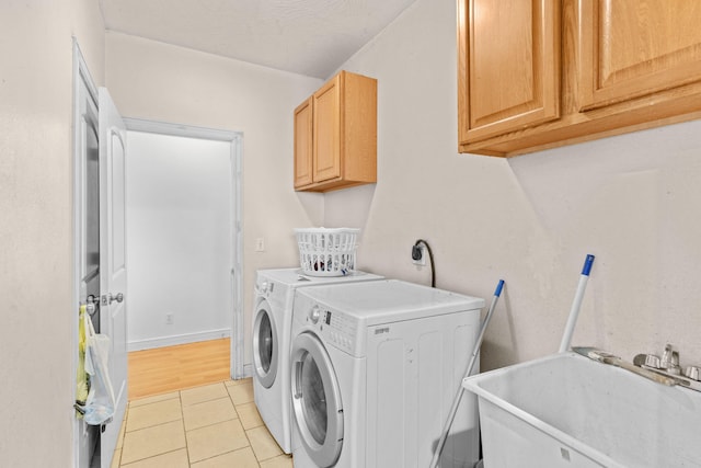 laundry room with washer and dryer, cabinet space, a sink, and light tile patterned floors