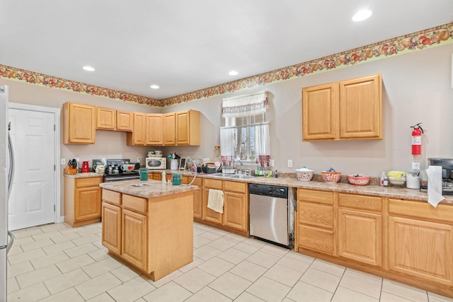 kitchen featuring a center island, recessed lighting, light brown cabinetry, appliances with stainless steel finishes, and a sink