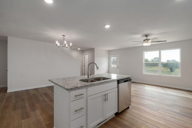 kitchen with stainless steel dishwasher, light wood-type flooring, a sink, and a healthy amount of sunlight