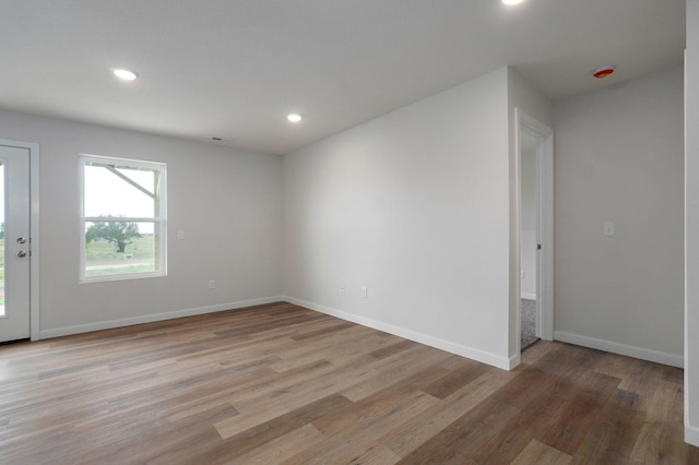 unfurnished room featuring light wood-style floors, recessed lighting, and baseboards