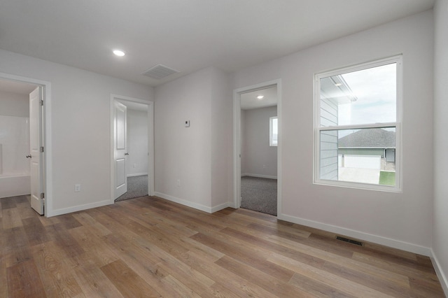 empty room featuring baseboards, visible vents, and light wood-style floors