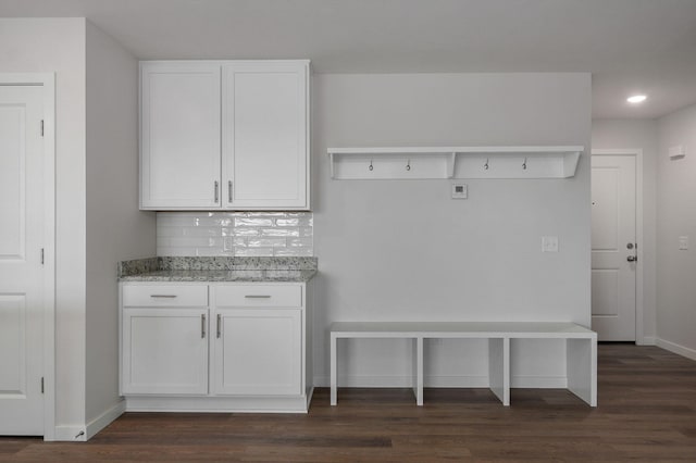 mudroom with recessed lighting, dark wood-style flooring, and baseboards