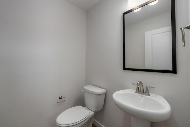 half bathroom featuring a sink and toilet