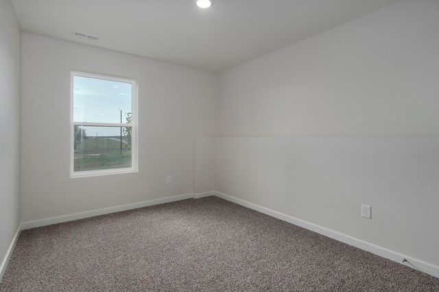 unfurnished room with carpet flooring, visible vents, and baseboards