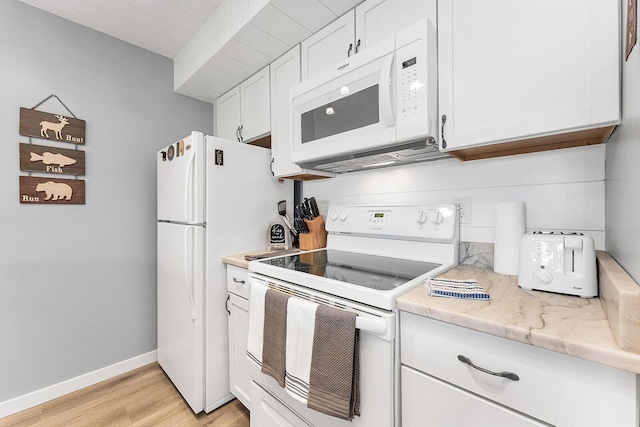 kitchen featuring white appliances, baseboards, white cabinets, light wood-style flooring, and light stone countertops