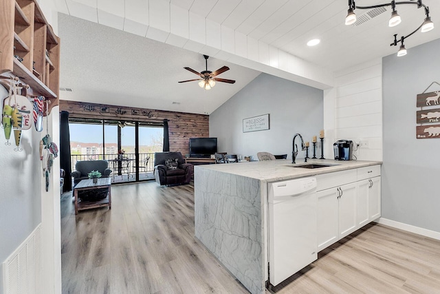 kitchen with light wood-type flooring, vaulted ceiling, dishwasher, and a sink