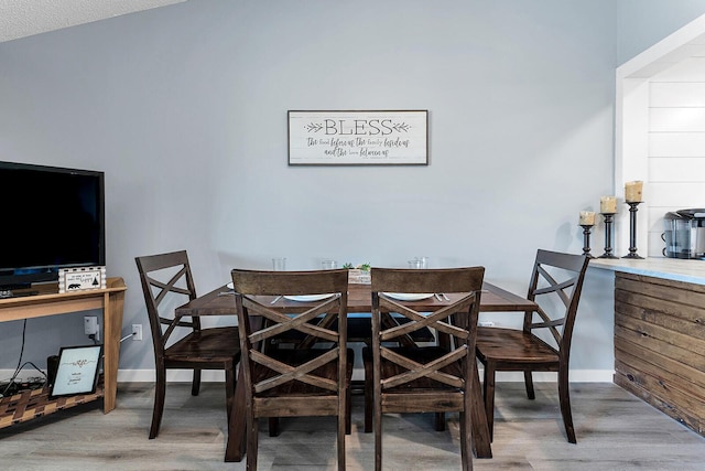 dining room with baseboards and wood finished floors