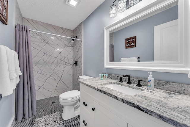 bathroom featuring toilet, a textured ceiling, a marble finish shower, and vanity